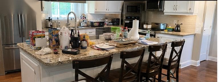 Kitchen before cleaning — cluttered counters and island